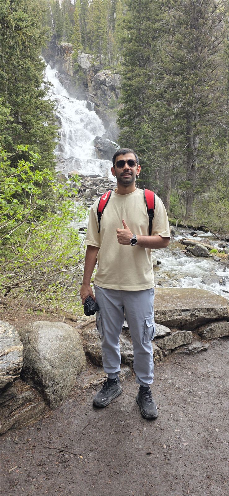 Rahul on a hike in front of a waterfall